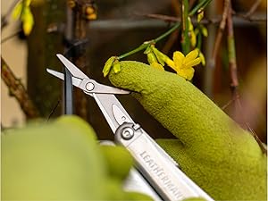 Photo of a person clipping the end of a zip tie with with the scissors of the Wave+ multi-tool