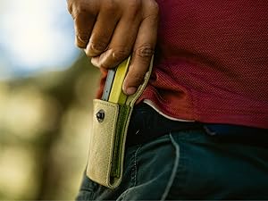 Photo shows person taking the Leatherman Bond multitool out of its sheath, attached to their belt