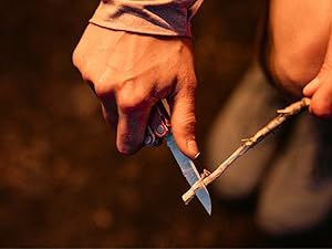 Photo shows person cutting a stick with the Leatherman Bond