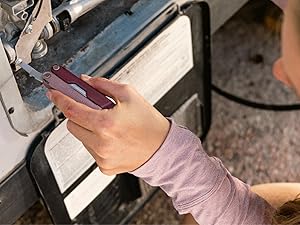 Phot of a person using the screwdriver on the Leatherman Bond to fix their RV