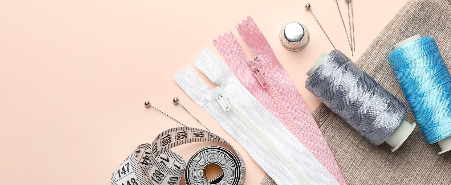 zipper, threads, needles, and meter on cloth