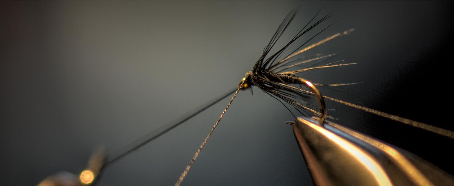 Burning off unwanted materials around hook eyes for fishing flies